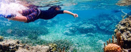 Underwater,Image,Of,7,Year,Old,Boy,Snorkeling,Through,Coral